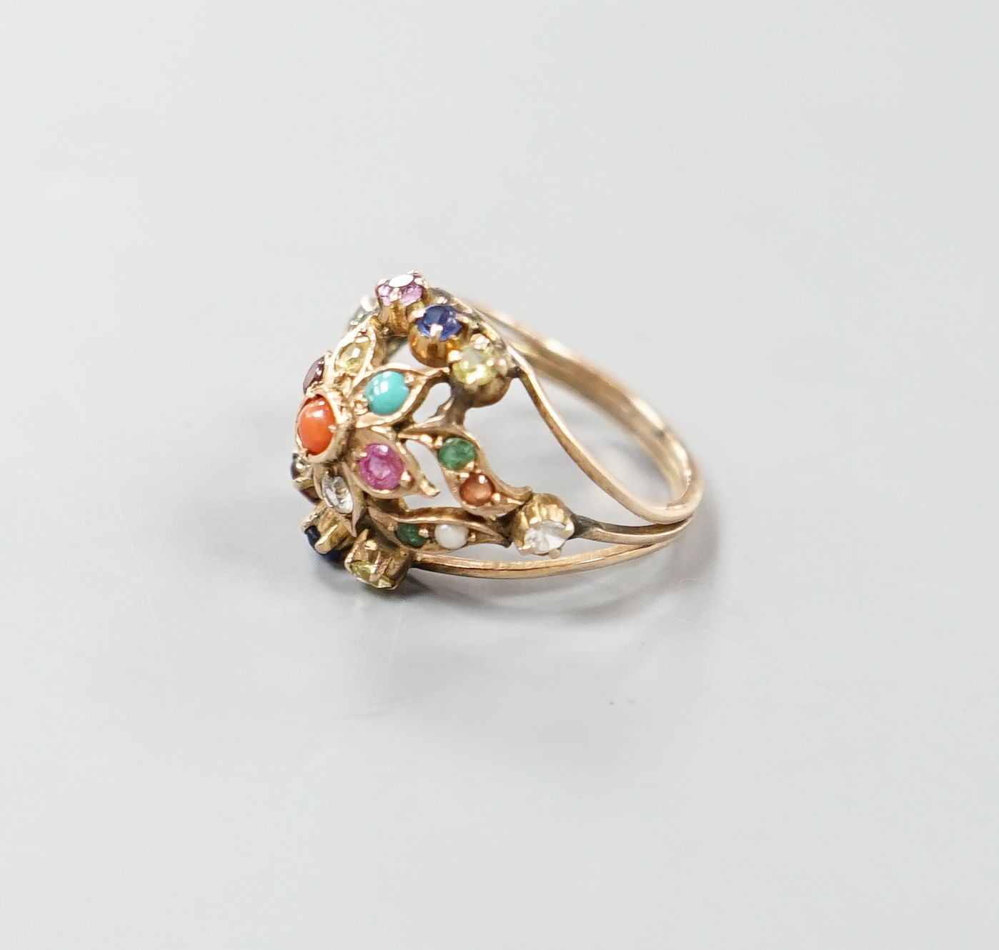 An early 20th century Arts & Crafts yellow metal and multi gem set set cluster ring, size H/I, gross weight 3.6 grams.